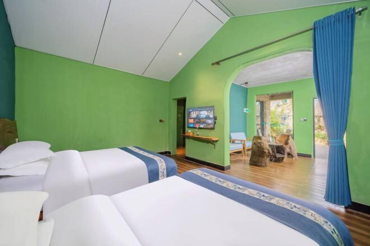 Une chambre d’hôtel avec deux lits, une télévision et une vue sur l’extérieur.