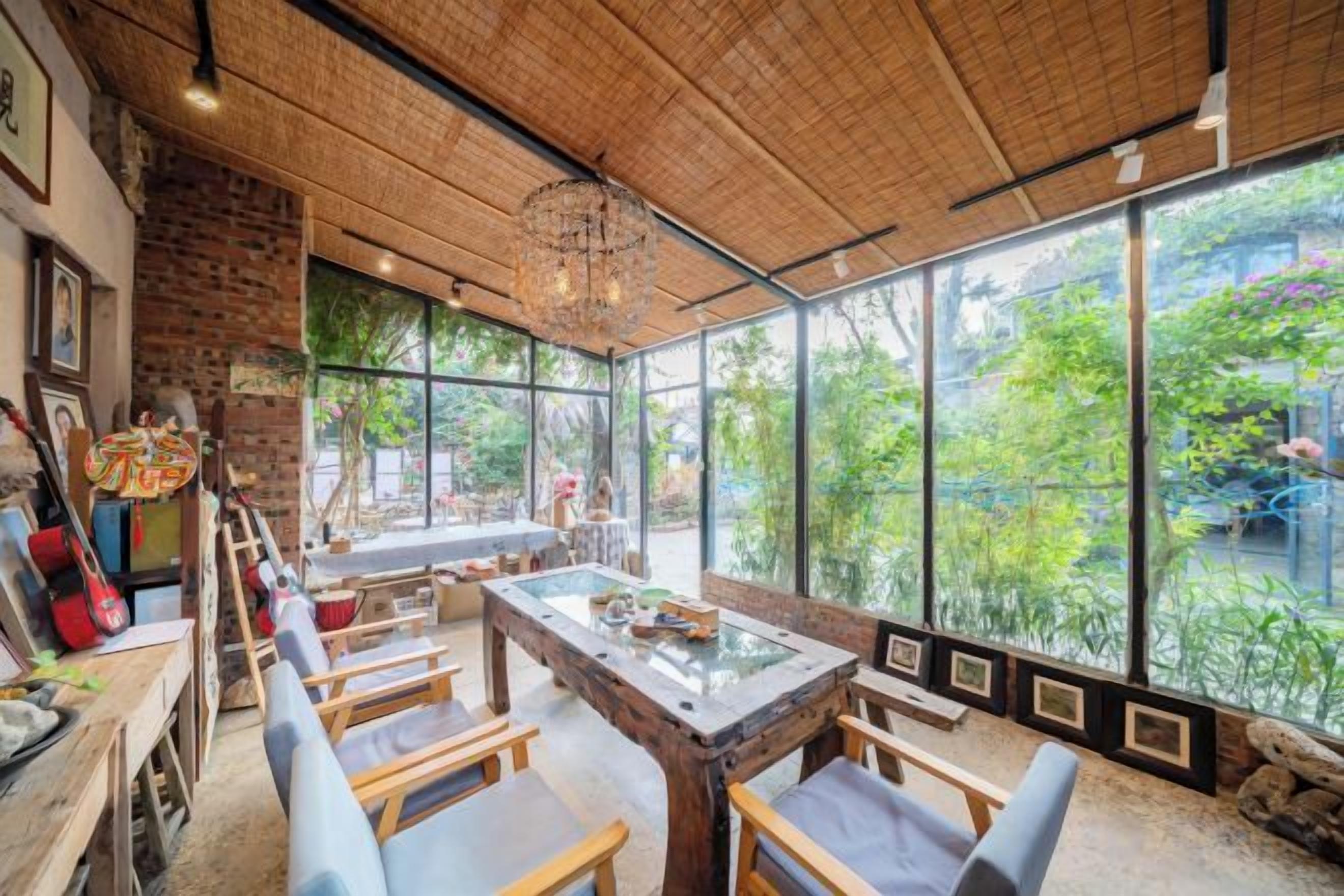 A room with a large glass window, a wooden table, and several chairs.