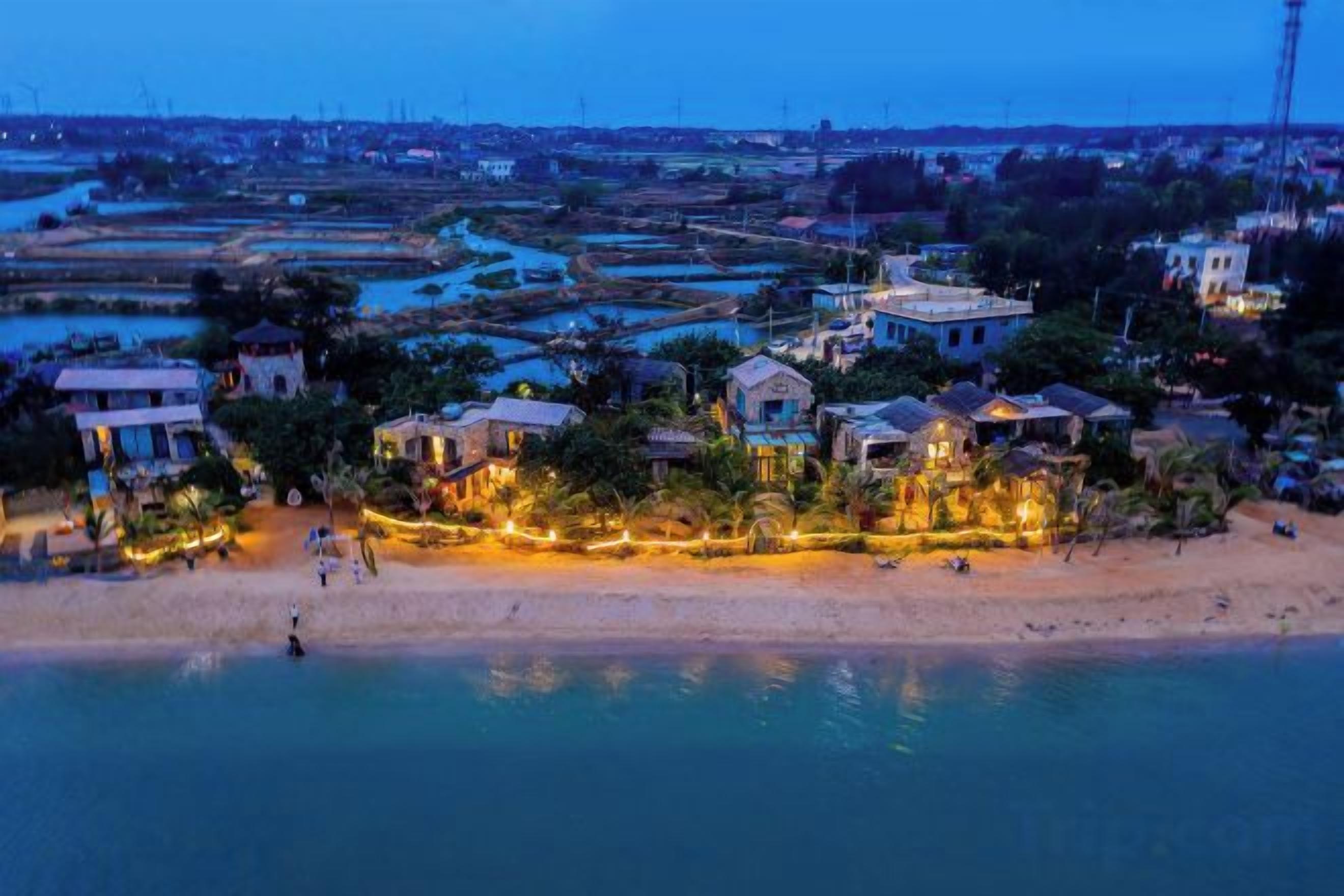 A coastal area with buildings, a beach, and water.