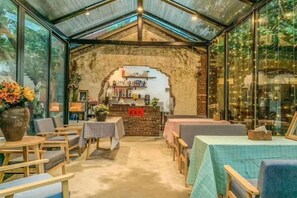 A rustic interior with a brick wall, wooden furniture, and a glass enclosure. - Xuwen Antarctic Village Artist Tribe (Xuwen)