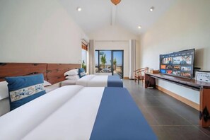 Ein Hotelzimmer mit zwei Betten, einem Fernseher und einem Balkon mit Blick.