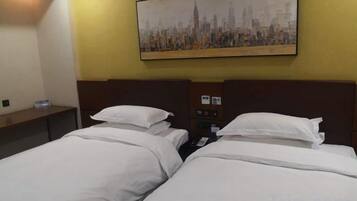 A hotel room with two beds, a nightstand, a painting of a cityscape, and a wall-mounted control panel.