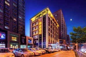 A hotel with multiple floors, a prominent sign, and a row of parked cars in front. - Yunpan Xiangyue hotel (Taiyuan)