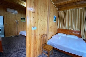 Una habitación con paneles de madera, una cama, una silla y un perchero.