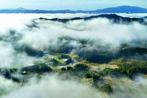 Un paysage composé de champs en terrasses et d’une vallée enveloppée de brume.