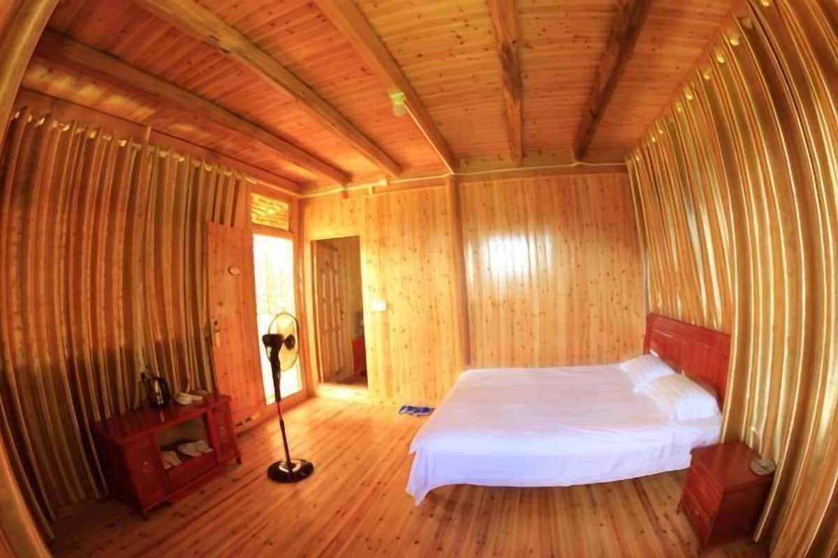 Una habitación de madera con una cama, un escritorio y una silla.