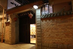A traditional building entrance with a wooden door and a lantern. - Dzongsa Book bar Inn (Shangri-La)