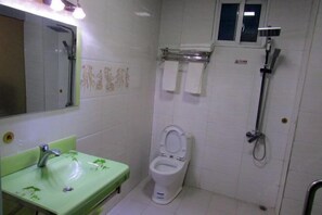 A bathroom with a green sink, a white toilet, a shower, and a mirror. - Dzongsa Book bar Inn (Shangri-La)