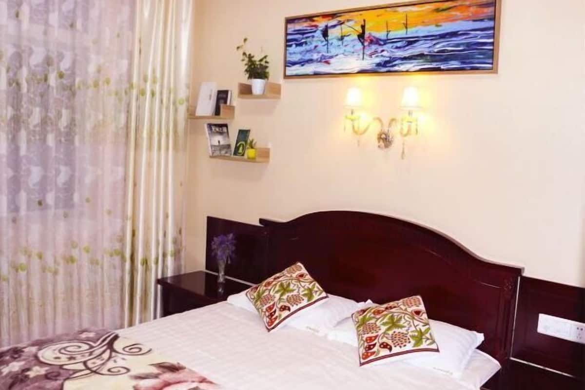 Un dormitorio con cama, un cuadro, luces empotradas en la pared y una mesita de noche.