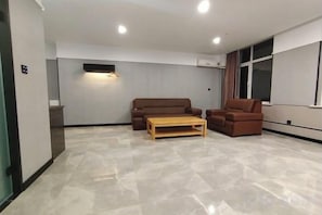 A spacious living area with a sofa, armchair, and coffee table. - Fushun Meilangshangwubinguan (Fushun)