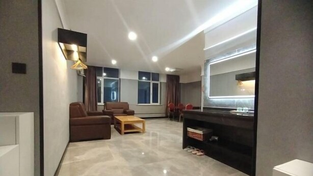 A modern living room with a sofa, chairs, a coffee table, and a TV. - Fushun Meilangshangwubinguan (Fushun)