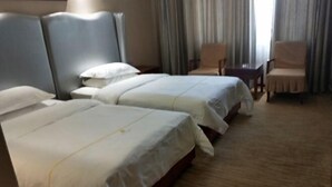 A hotel room with two beds, a desk, and two chairs. - Dihao Hotel (Ruoqiang)