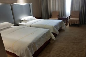 A hotel room with two beds, a desk, and two chairs. - Dihao Hotel (Ruoqiang)