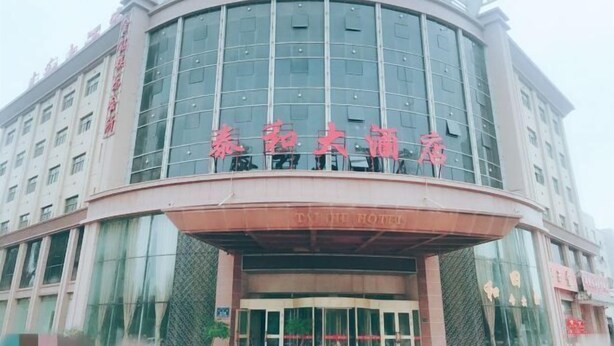 A hotel with a modern glass facade and a curved entrance. - Dihao Hotel (Ruoqiang)