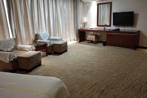 A hotel room with a large bed, two armchairs, a small sofa, a desk with a lamp, a television, and a large window with curtains. - Dihao Hotel (Ruoqiang)