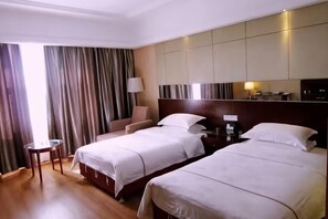 A hotel room with two beds, a desk, a chair, a lamp, and a large window with curtains. - Dihao Hotel (Ruoqiang)