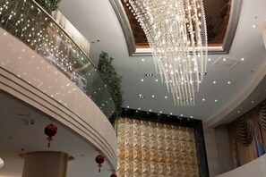 A multi-level interior with a grand chandelier, decorative lights, and a patterned wall. - Dihao Hotel (Ruoqiang)