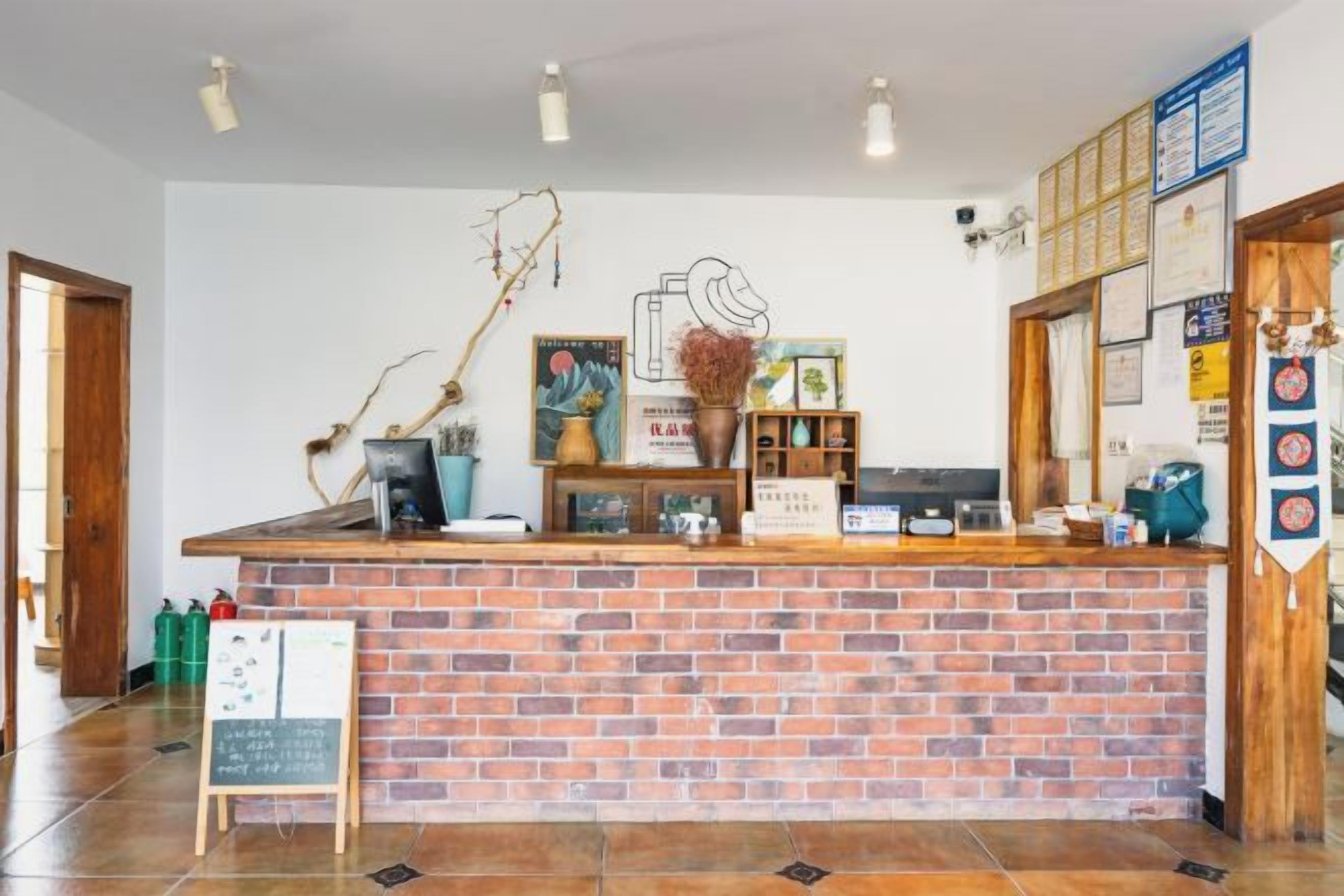 Un área de recepción con mostrador de ladrillo, una pizarra y varios objetos decorativos.