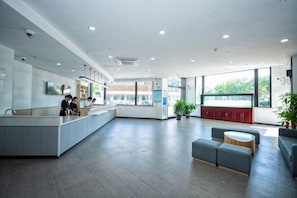 A modern hotel lobby with a central island, seating area, and large windows. - Wanting Hotel (Shanghai Xinchang ancient town store) (Shanghai)