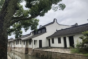 A traditional building with a tiled roof, white walls, and a stone pathway. - Wanting Hotel (Shanghai Xinchang ancient town store) (Shanghai)