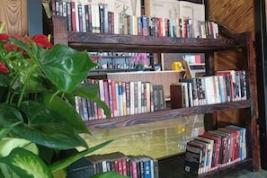 A bookshelf with books and a potted plant. - Wanting Hotel (Shanghai Xinchang ancient town store) (Shanghai)
