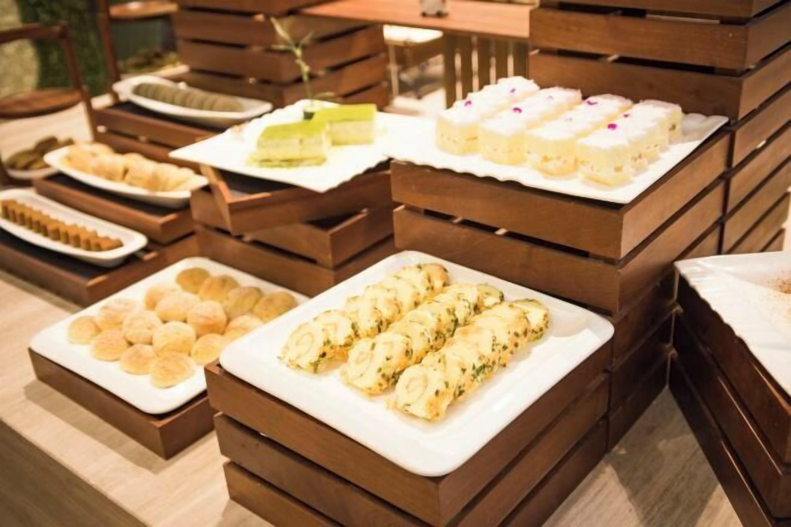 Een buffet met verschillende soorten eten, gerangschikt op houten presentatietafels.