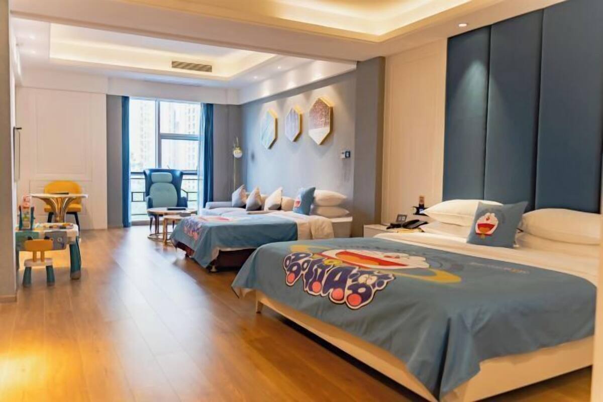 A hotel room with two beds, a desk, and a chair.
