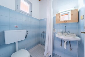 A bathroom with a toilet, shower, sink, and a window. - Studio Apartment 'Maltas  17' with Shared Terrace, Wi-Fi and Air Conditioning (Corfu)