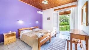 A bedroom with a wooden ceiling, a bed with white linens, a nightstand, a desk, and a view of greenery outside. - Studio Apartment 'Maltas  17' with Shared Terrace, Wi-Fi and Air Conditioning (Corfu)
