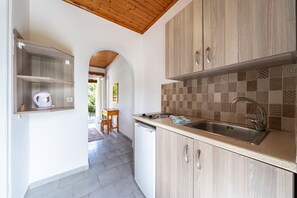 A kitchen with wooden cabinets, a sink, and a dishwasher.