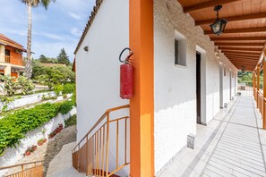 A corridor with a white wall, red fire extinguisher, and a wooden railing. - Studio Apartment 'Maltas  20' with Shared Terrace, Wi-Fi and Air Conditioning (Corfu)