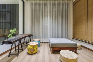 A room with a bed, a small table, and a window with curtains. - Tingxiju Inn (Xianju)