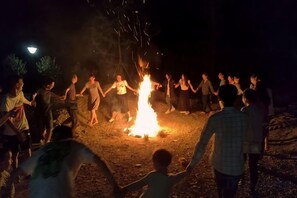 A group of people gathered around a campfire at night. - Tingxiju Inn (Xianju)