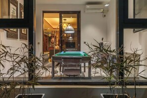 A billiards table in a room with a doorway leading to another area with a lamp. - Tingxiju Inn (Xianju)