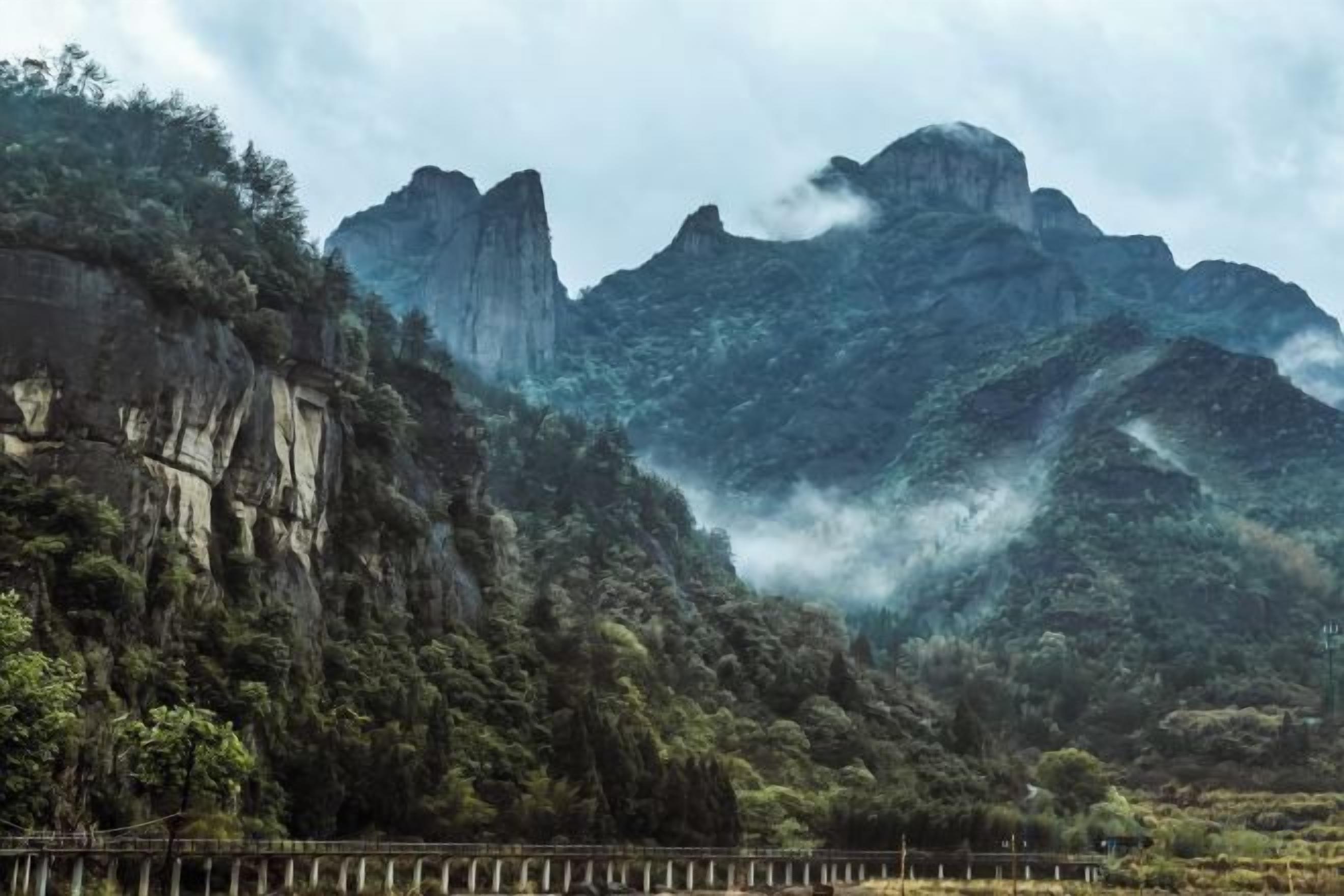 Un paisaje montañoso con una valla de madera al frente.