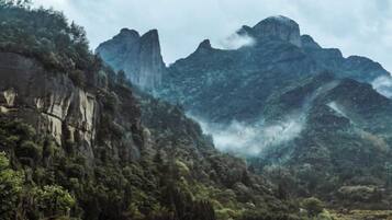 Un paisaje montañoso con una valla de madera al frente.