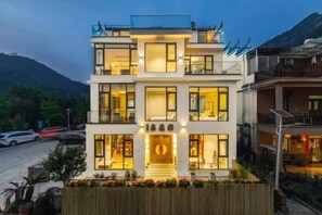 A multi-story hotel with a modern design, featuring balconies and large windows.