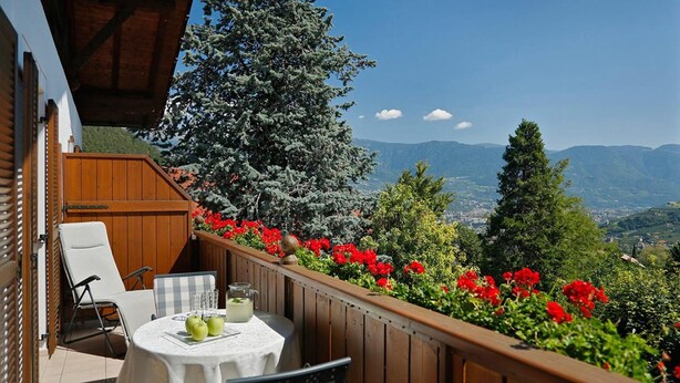 A balcony with a table, chairs, and a view of mountains. - Wiedmairhof Apartment 'Grafensteiner' with South/east facing balcony, Shared Terrace, Garden & Wi-Fi (Lagundo)