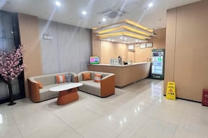 A hotel lobby with a reception desk, seating area, and a vending machine. - Anna Baige Hotel (Shanghai)