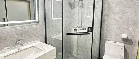 Ein modernes Badezimmer mit einer gläsernen Dusche, einem Waschbecken und einer Toilette.