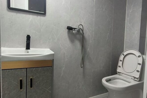 A bathroom with a white sink, a toilet, and a shower head. - Xinyue Hotel (Taiyuan Ophthalmology Hospital) (Taiyuan)