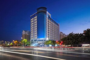 A high-rise hotel with a modern design, featuring a prominent corner structure and multiple floors. - Jinjiang Inn (Zhengzhou High-speed Railway East Station Zhengdong MixC Branch) (Zhengzhou)