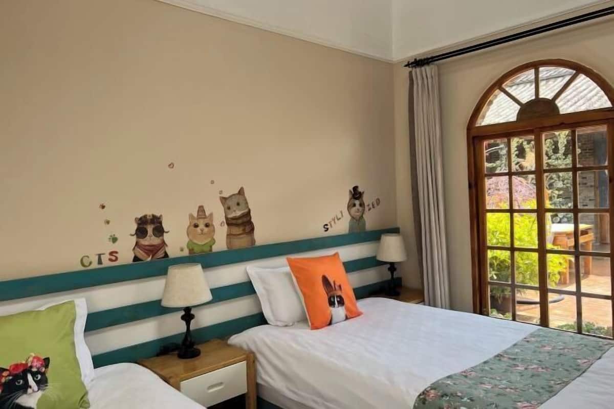Une chambre à coucher comprenant un lit, des tables de chevet, une fenêtre avec des rideaux et des éléments de décoration murale.