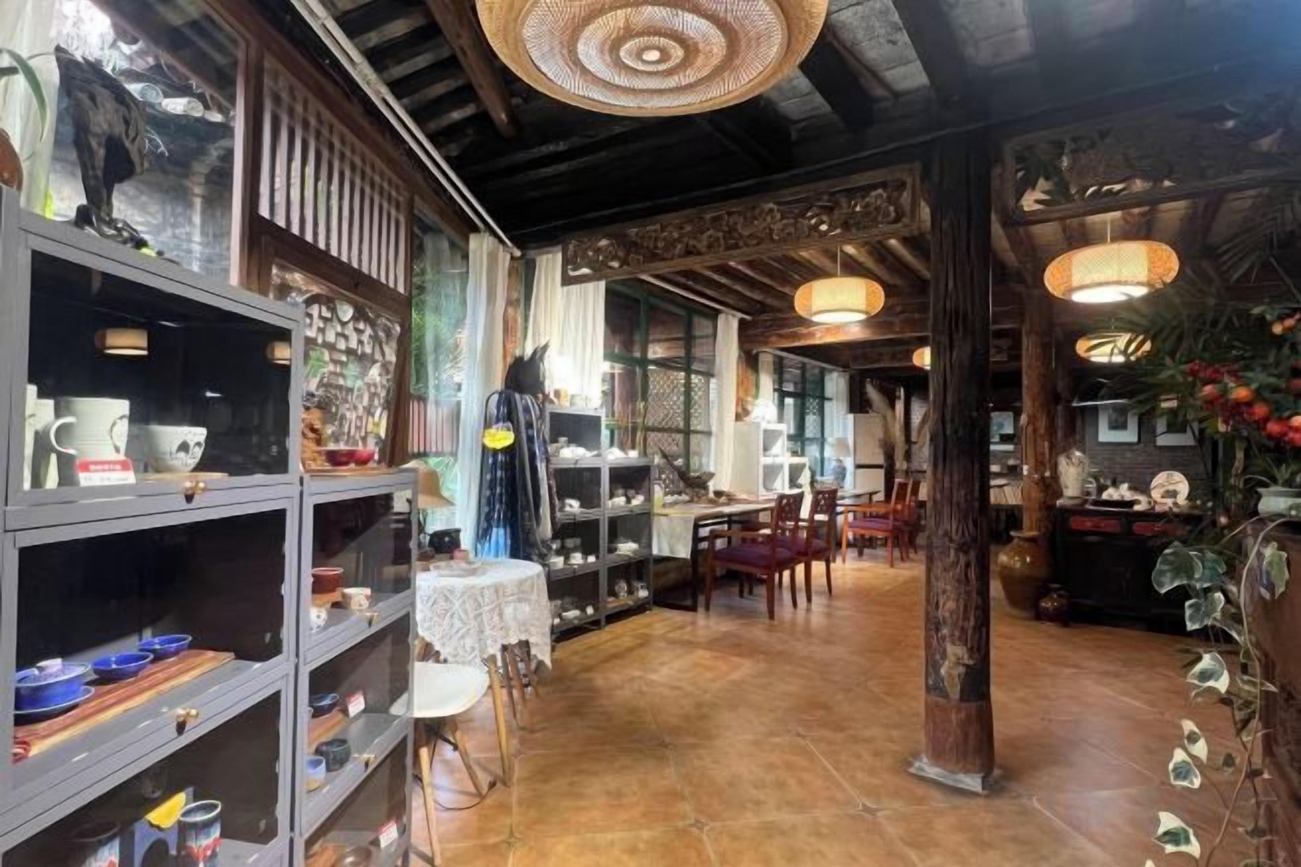 Un interior amplio con estantes llenos de vajilla, un comedor y una columna central.