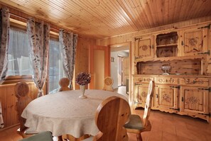 Un intérieur en bois avec une table ronde, des chaises et des armoires.