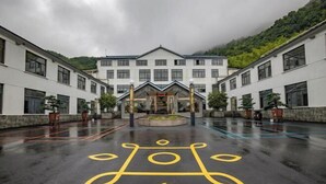 A modern building with a symmetrical facade, large windows, and a central entrance. - Tiantang Mountain Original Ecological Resort (Guangde)