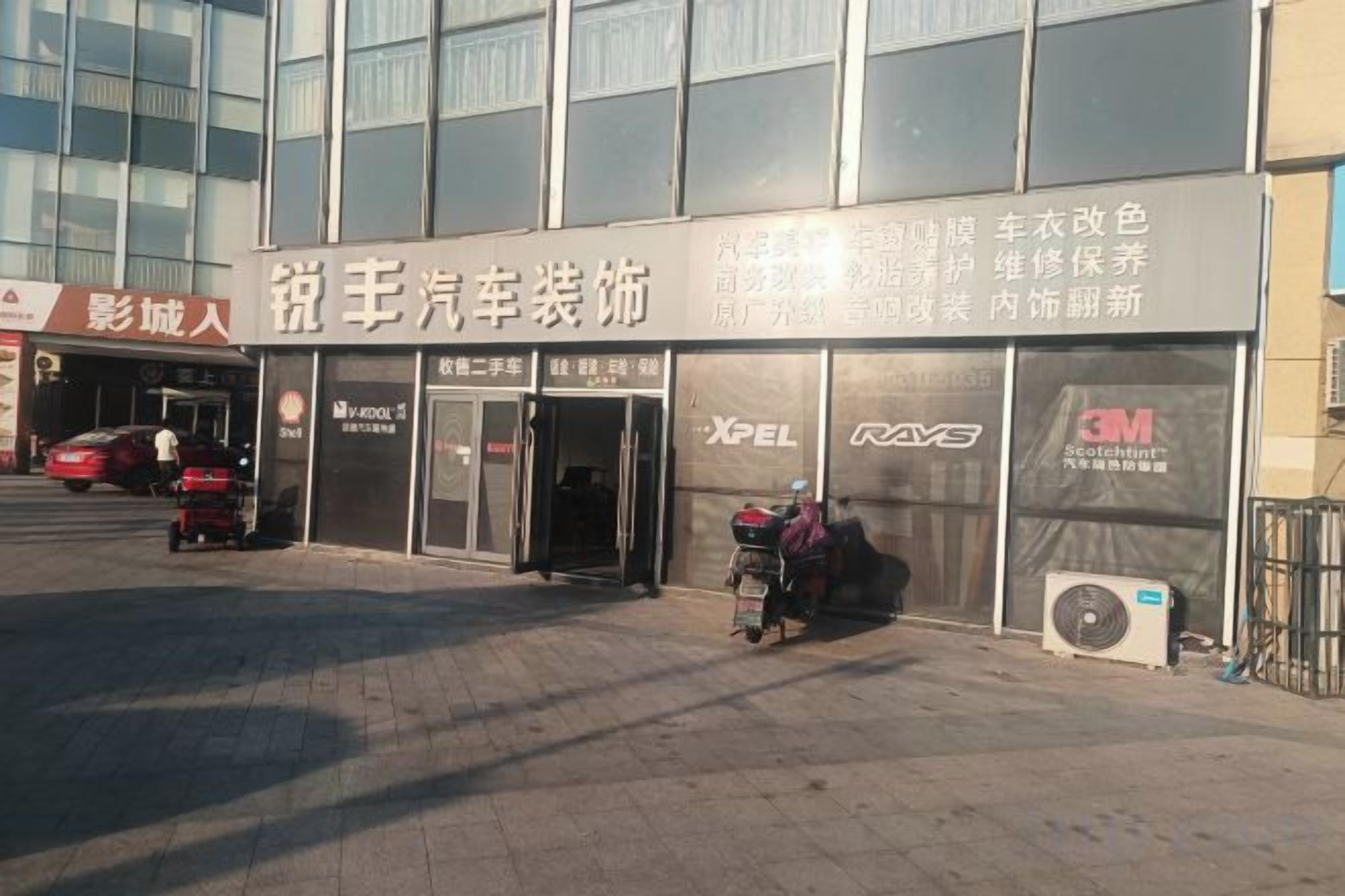 A building with a sign for a car dealership and a motorcycle service area.
