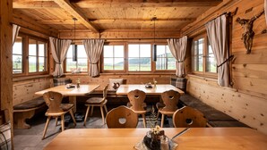 Un intérieur en bois comprenant un coin repas, des bancs et un crucifix accroché au mur.
