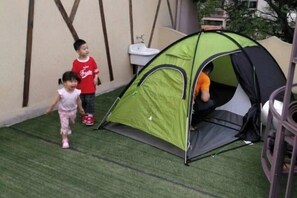 A green tent set up on artificial grass with a sink and a chair nearby. - Shanghai Yuanlai Chinese Inn Cenbocun (Shanghai)