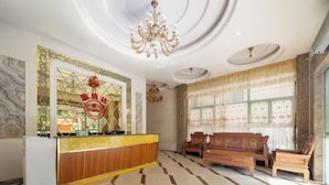 A reception area with a marble floor, a wooden reception desk, a chandelier, and a large window with curtains. - Costa Resort（Xiachuan Island） (Taishan)